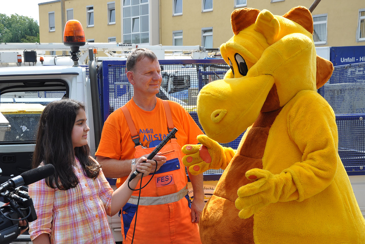 Fessie-Maskottchen mit FES-Mitarbeiter und Kinderreporter
