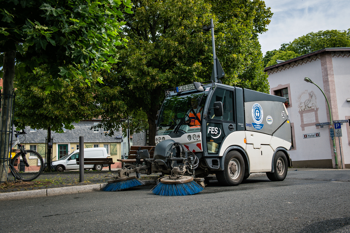Kleine Kehrmaschine reinigt Straßenrand