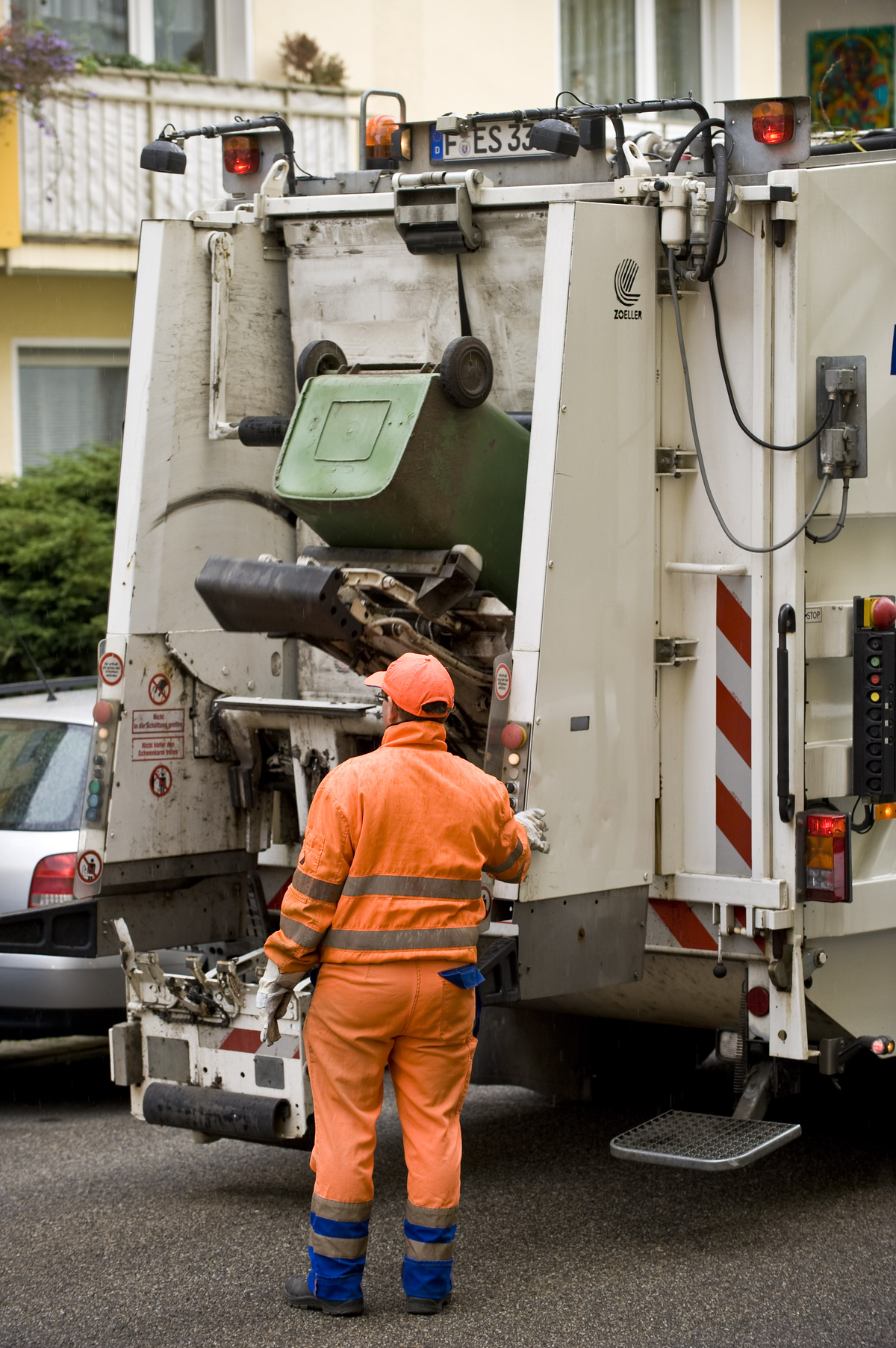 Mitarbeiter leert Müll in Müllfahrzeug