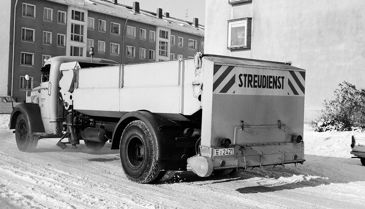 Schwarzweißbild eines alten FES-Fahrzeugs mit Mülltonnen
