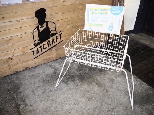 Stuhl aus recyceltem Material vor Holzrückwand mit LABL-Logo und Schild