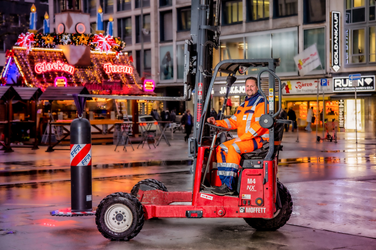 Motiv "Kleider machen Leute" 2026 - Mitarbeiter fährt mit dem Gabelstapler und stellt mobile Straßensperre auf